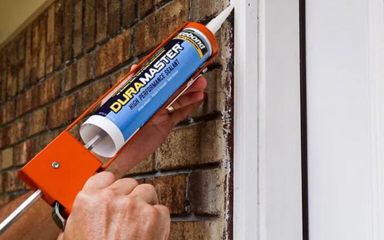 Man caulking an entry door's exterior casing.